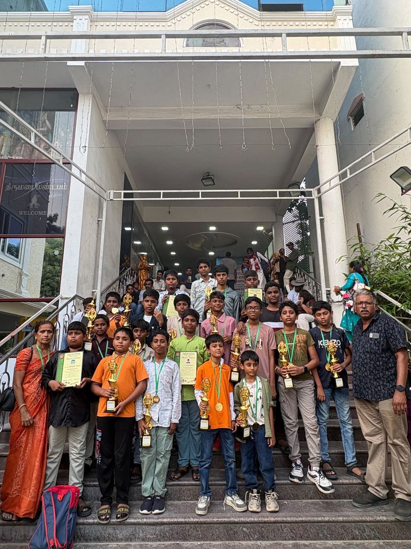 கோப்பைகள் மற்றும் சான்றிதழ்களுடன் நிற்கும் மாணவர்கள்
